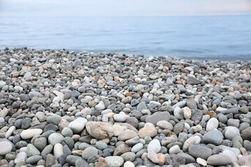 Fototapeta na wymiar Picturesque view of beach with pebbles near sea