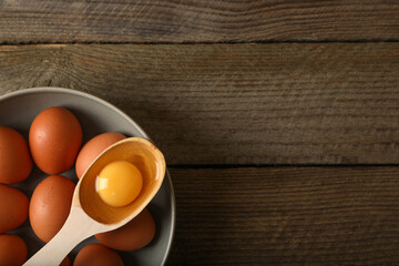 Raw chicken eggs on wooden table, top view. Space for text