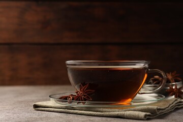 Aromatic tea with anise stars on light grey table. Space for text