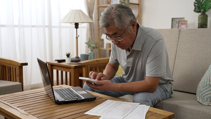 Retirement financial planning concept. senior asian man counting on calculator with family budget...