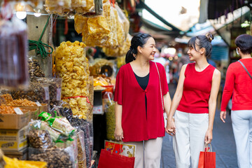 Happy Asian family mother and daughter choosing and buying raw food and groceries for cooking...