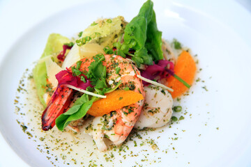shrimp seafood salad food with vegetables, orange and herbs on white plate background