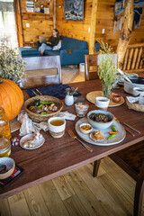 Plates of food on a wooden table in a rustic cabin in the Rocky mountains - family dinner gourmet vegan lifestyle
