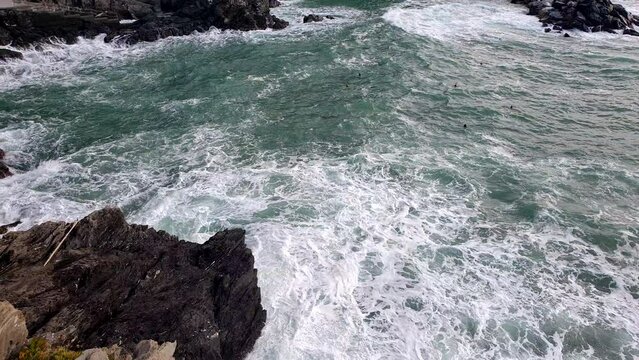 Strong ocean wave splashing over cliff rock high angle top view nature background slow motion video scene