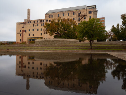 The Oklahoma City National Memorial And Survivor Tree With Autumn Foliage With Reflection In The Reflecting Pool