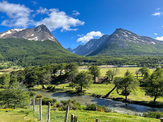 The Andes Mountains of Patagonia near Ushuaia Argentina near the entrance to Tierra del Fuego National Park with horses roaming the valley meadow along the clear creek