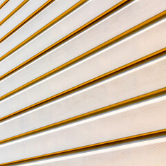 Part of the wall of a private house covered with plastic beige siding.