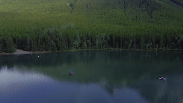 Boats on pond in park mountains and forest circling, Rockies, Kananaskis, Alberta Canada