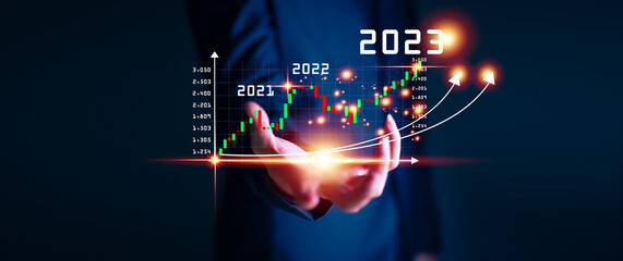 Businessman hand touching and pointing on year 2023 with virtual screen from 2022 to 2023, Businessman plan and increase of positive indicators in his business, Growing up business concepts.