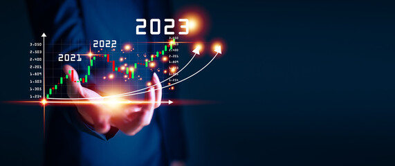 Businessman hand touching and pointing on year 2023 with virtual screen from 2022 to 2023, Businessman plan and increase of positive indicators in his business, Growing up business concepts.