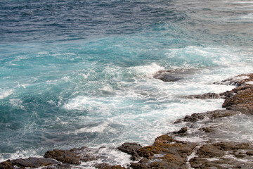 Rocky sea coast. Beautiful turquoise waters of the Sea. Ocean waves against the coastal rocks. Scenery view on ocean. Wonderful summer seascape.