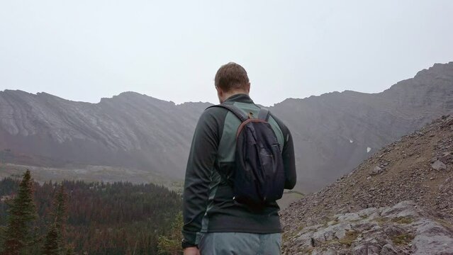 Hiker in light snow looking for trail circled. Rockies Kananaskis Alberta Canada
