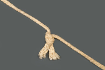 Rope with a knot on a gray background.