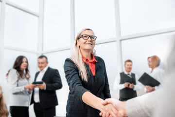 smiling businesswoman shaking hands with her business partner.