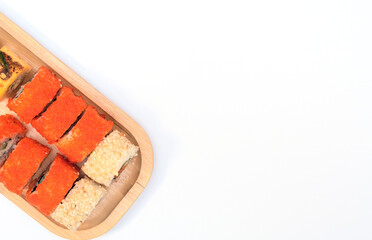 Delicious Japanese rolls with salmon, avocado, cucumber, cheese on wooden plate with selective focus on white background. Asian food concept. Healthy eating