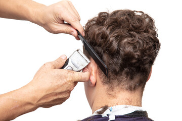 The hairdresser cuts a man's haircut with a clipper