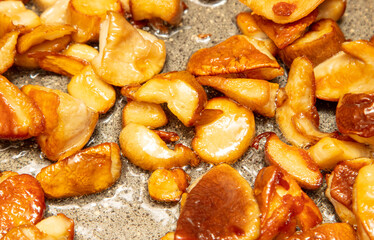 Fried mushrooms in oil in a frying pan.