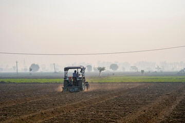 Indian farmer working with tractor in agriculture field. © Niks Ads