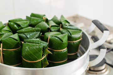 Thai desserts sticky rice bundle wrapped banana leaves in a container