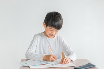 学校の教室で漢字・国語の勉強をする小学生の男女（笑顔・男子・授業・教育）
