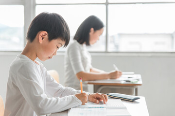 学校の教室で漢字・国語の勉強をする小学生の男女（男子・授業・教育）
