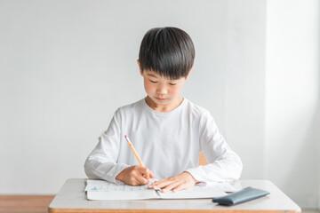 学校の教室で漢字・国語の勉強をする小学生の男女（男子・授業・教育）
