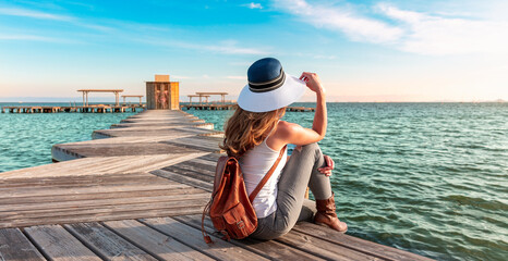 one woman sits on a wooden pier.  Relaxing,  travel,