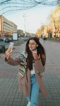 Stylish female traveler taking selfie or video for internet blog.