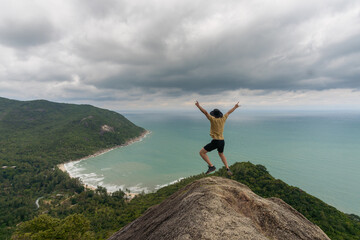 man jumping in a top of view point on bottle beach, blue sky with clouds and beautiful tropical beach,koh phangan, Ko Pha-ngan, Surat Thani,thailand