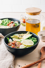 Buddha bowl with crispy sesame chicken asian style. Sweet and sour fried chicken with steamed rice, peas and acocado