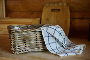 Rustic kitchen items. Wicker basket on the kitchen table in a log house