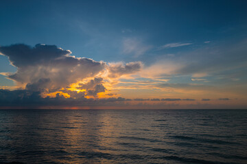 Naklejka na ściany i meble Cloudy sky on sea sunset, sunrise on ocean beach. Sunset landscape in the sky after sunset. Caribbean sea. Sunrise with clouds of different colors against the sky and sea.