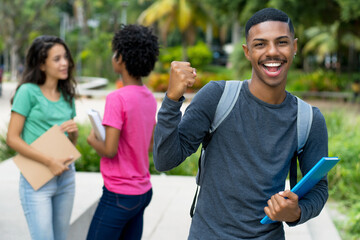 Cheering african american male student with group of brazilian female young adults