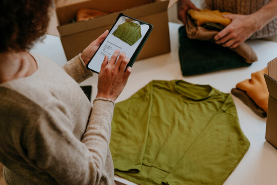 Young fashion designer using tablet PC in workshop
