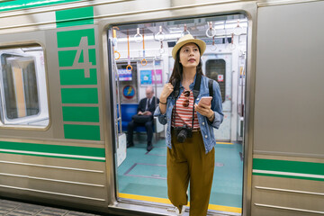 asian female tourist looking for transfer direction sign as she gets off the train with number four...