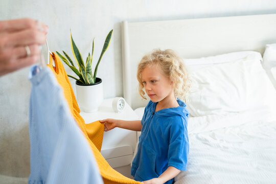 Girl Choosing Dress In Bedroom At Home