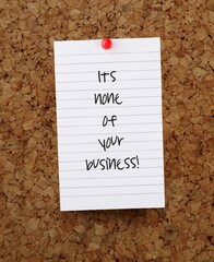 paper note pinned on cork board written IT'S NONE OF YOUR BUSINESS , to tell someone not to get...
