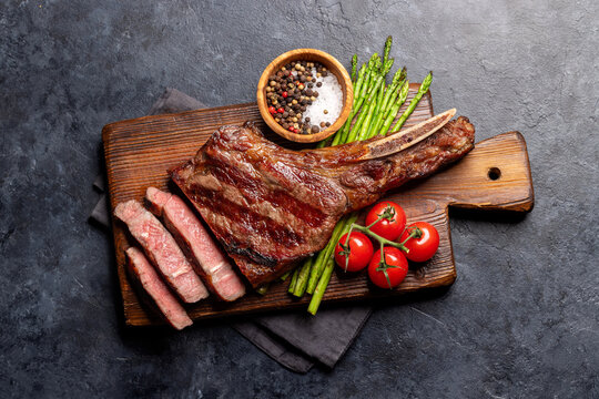 Medium rare grilled Tomahawk beef steak with asparagus