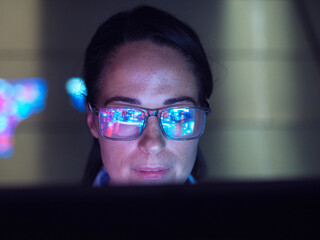 Engineer examining AI technology with reflection on eyeglasses