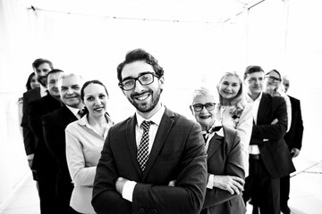 close up. smiling businessman standing in front of a big business team.
