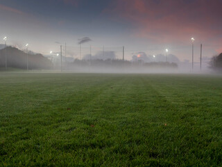 Irish National sport ground wit tall goal posts for camogie, hurling, rugby, Gaelic football at dusk and low fog over the ground. Calm and peaceful mood. Sport activity concept. - obrazy, fototapety, plakaty