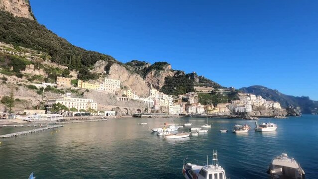 Panoramic view of beautiful Amalfi on hills leading down to coast, Campania, Italy. aerial skyline of small haven of village with tiny beach and colorful houses, located on rock and mountains