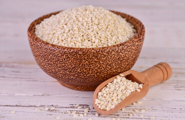 Sesame seeds in a wooden bowl on a white background.Close-up.
