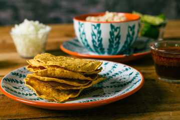 Tostada of corn, typical mexican food. Tostadas on a plate on a wooden table.