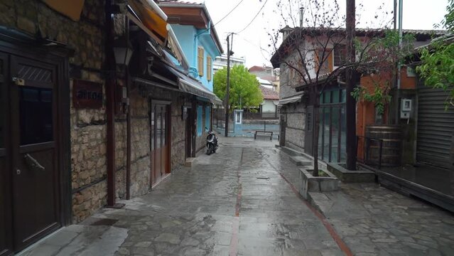 Wet Cobble Stone Street in a picturesque Kyriotissa quarter with tall buildings