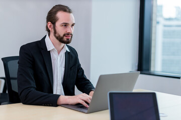 Business Man busy working on laptop computer at office. Businessman Using Laptop In Modern Office