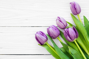 Bouquet of purple tulips, a bouquet of spring flowers on a white wooden background, flat lay, copy space.