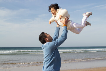 Father and daughter travelling together. Japanese family walking, laughing, fooling around, lifting child up. Dad leisure, family time, parenting bright