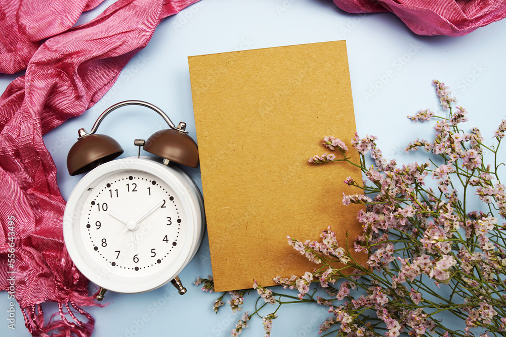 Poster Empty card mockup with alarm clock and pink scarft on blue background