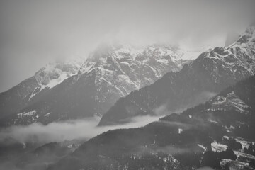 Fototapeta na wymiar Dreamy mysterious winter landscape with fog and snow covered mountains and trees